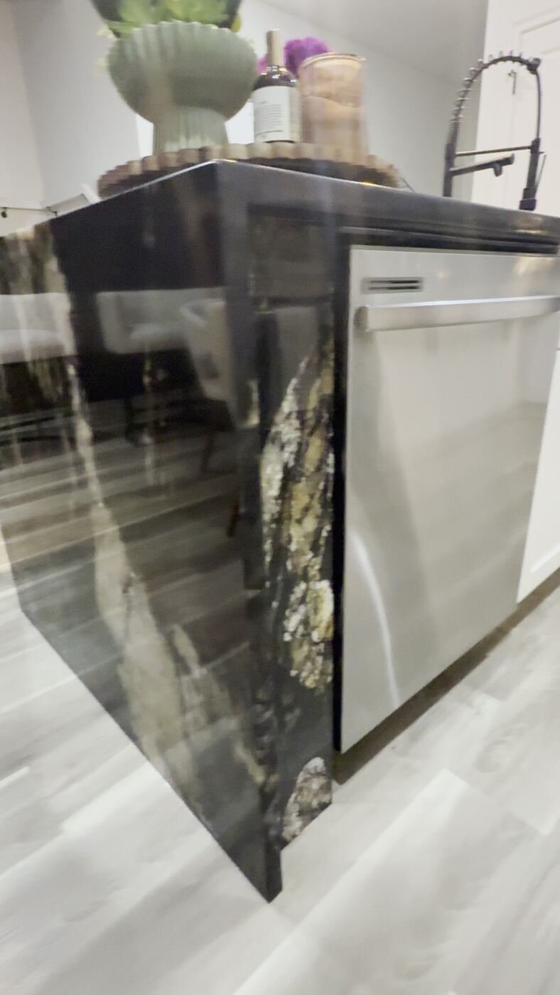Black and gold granite waterfall island by Stone Experience